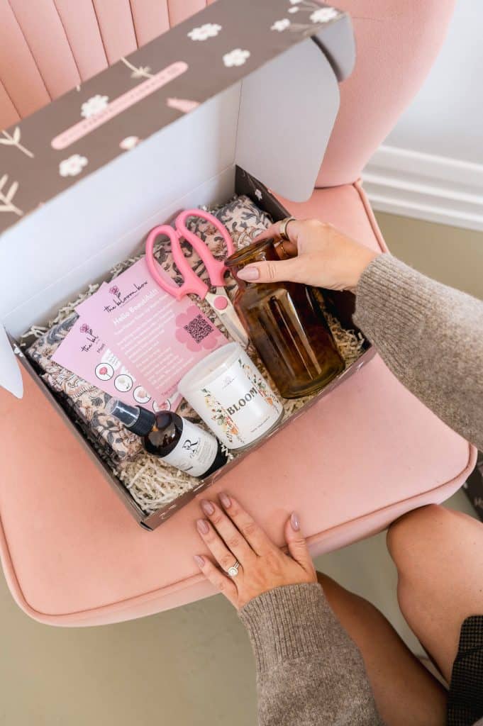 Gift box with floral supplies, scissors, and skincare products for special occasions.