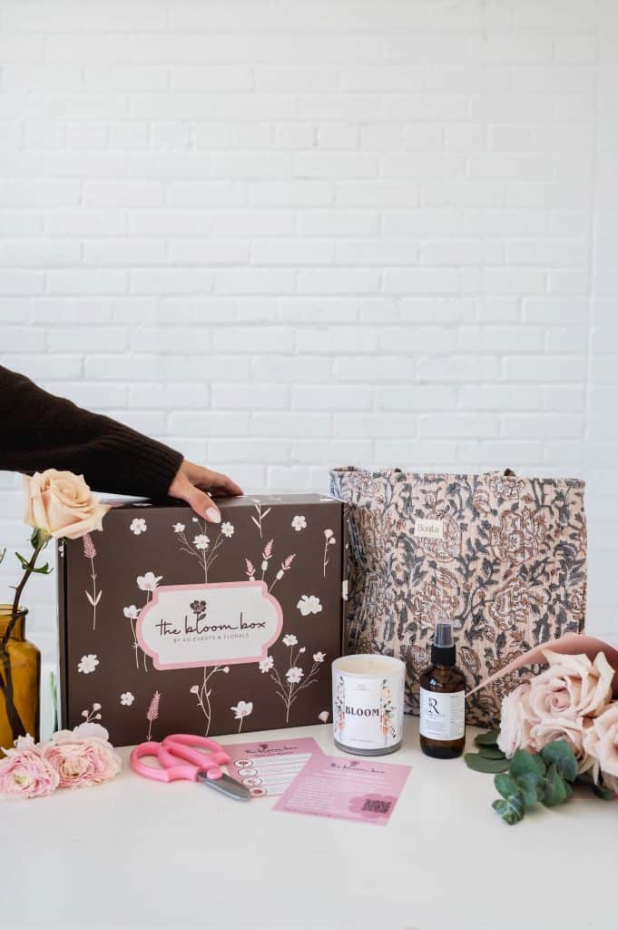 Elegant floral arrangement with gift box and floral care products.