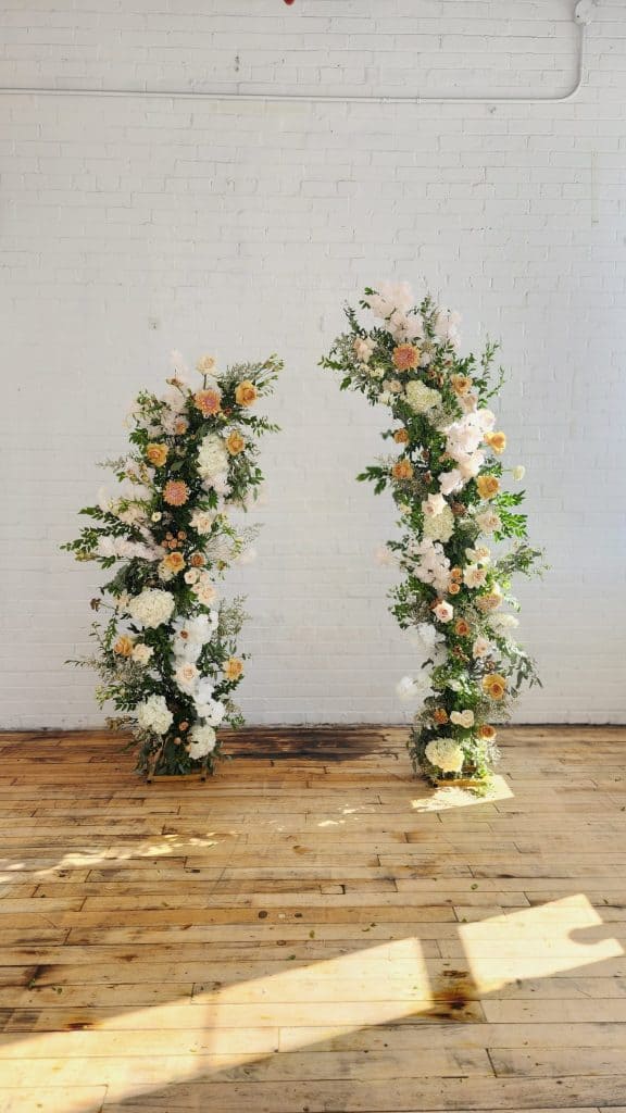 Beautiful floral arch with roses and greenery for wedding or event decor.
