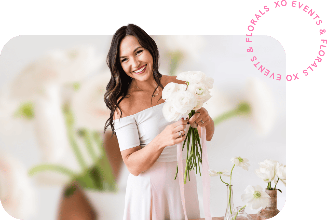 Smiling woman holding a bouquet of white roses at XO Flowers event.