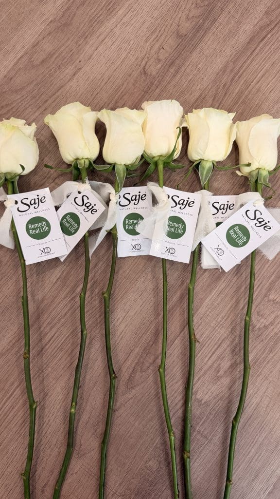 Elegant white roses with tags for event floral arrangements.